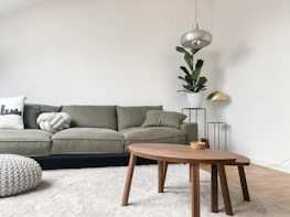 A peaceful living room with soft beige and sage green tones, reflecting calm and care.
