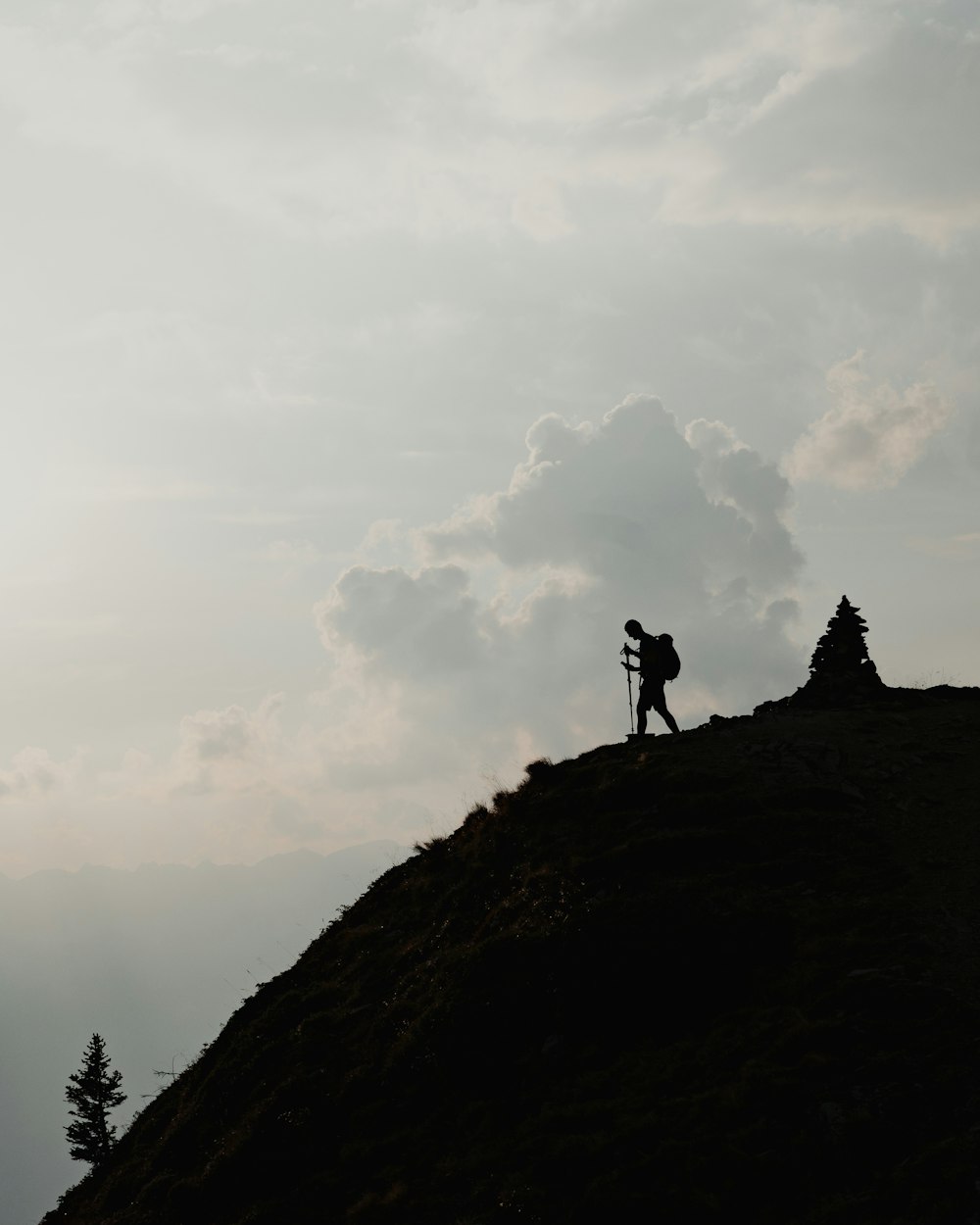 silhouette of person standing on top of mountain during daytime