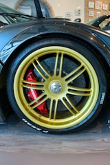 Elegant golden brake caliper mounted on a luxury European car wheel.