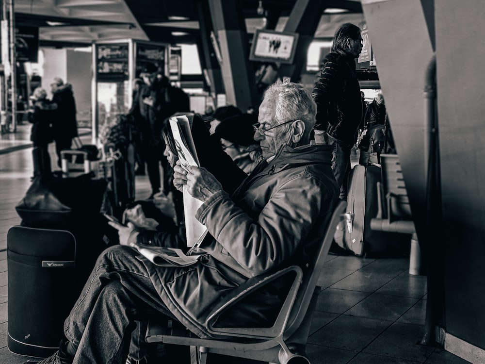 man in gray jacket sitting on chair