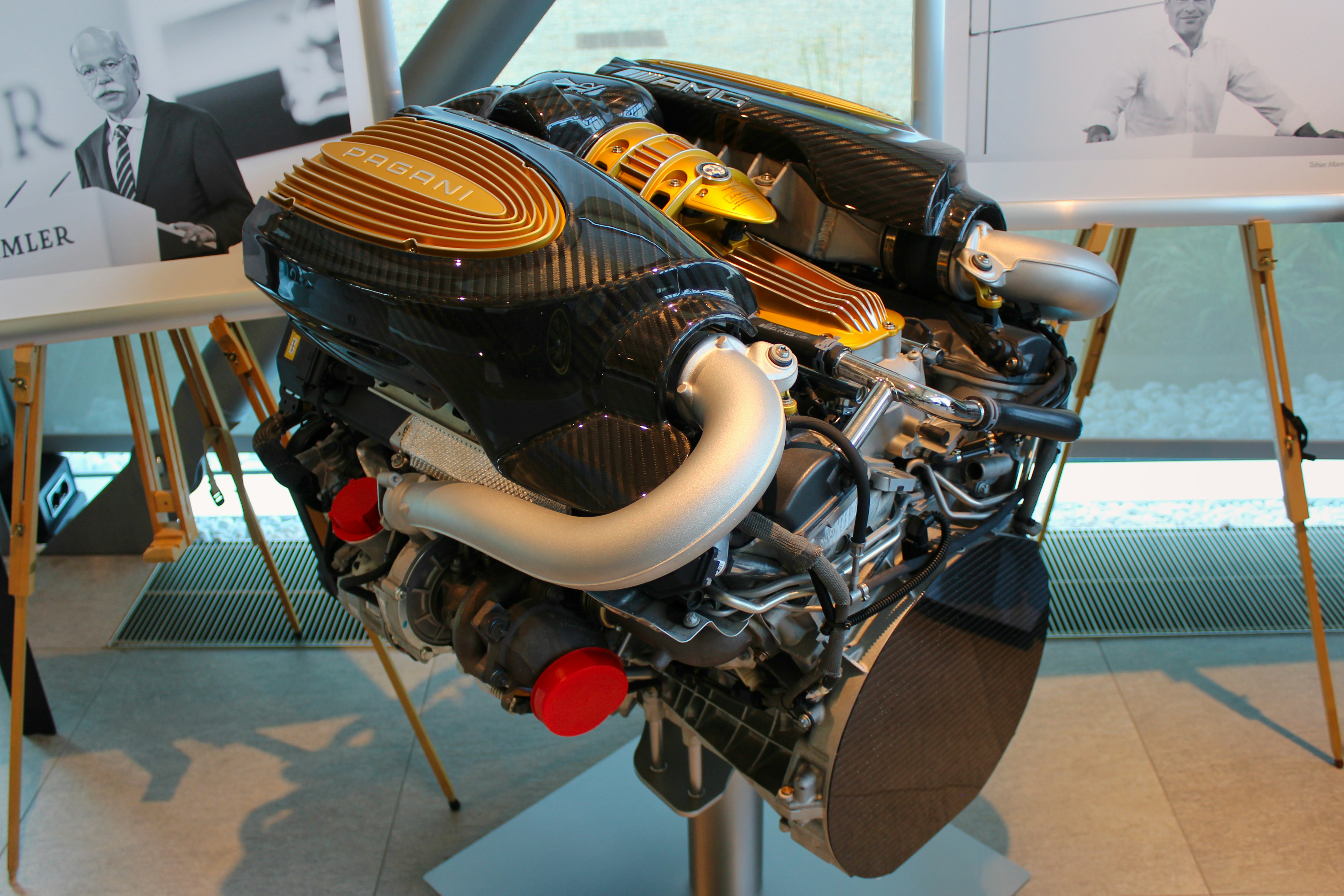 Exotic supercar engine bay showing hand-crafted components — similar to the AMG V12 found in Pagani Zonda