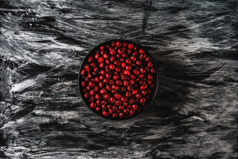 red round fruit on black and white surface