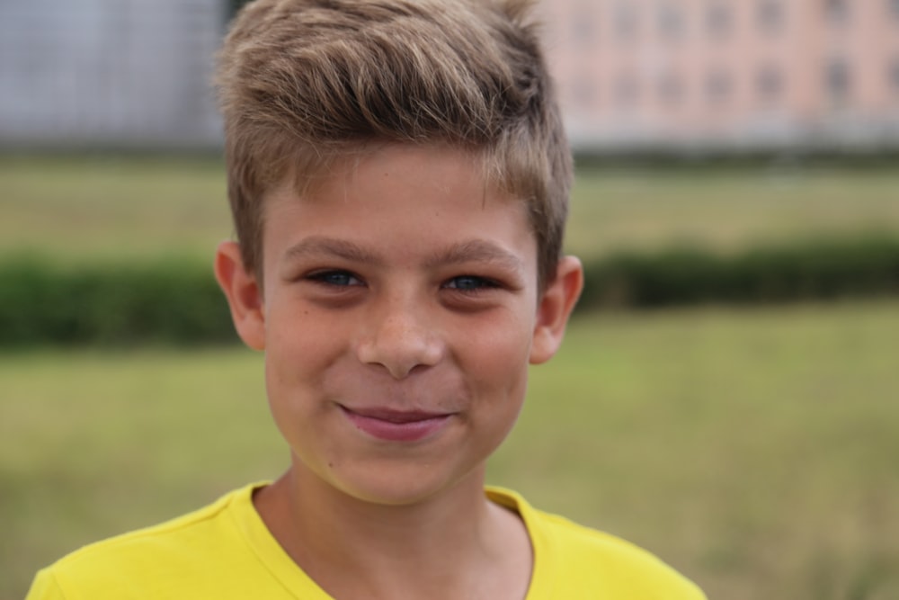 boy in yellow crew neck shirt smiling