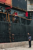 Crew members coordinating operations on the deck of a cargo ship.