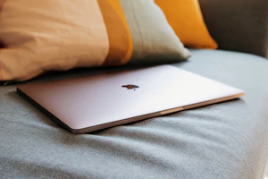 Sleek leather MacBook sleeve resting on a cream fabric background