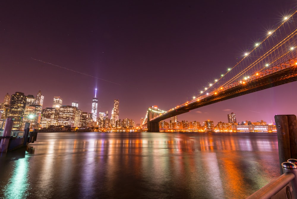 lighted bridge over water during night time