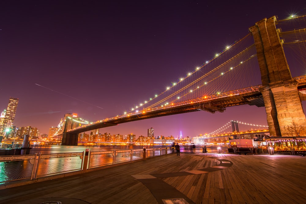 lighted bridge over water during night time