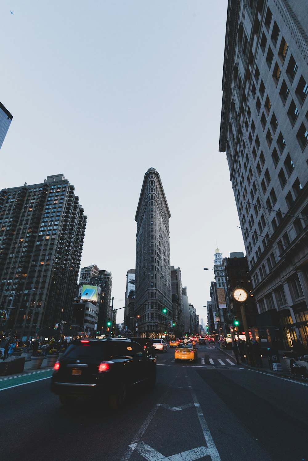 cars on road between high rise buildings during daytime