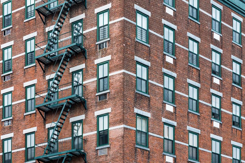 Edificio de ladrillo marrón con valla metálica negra