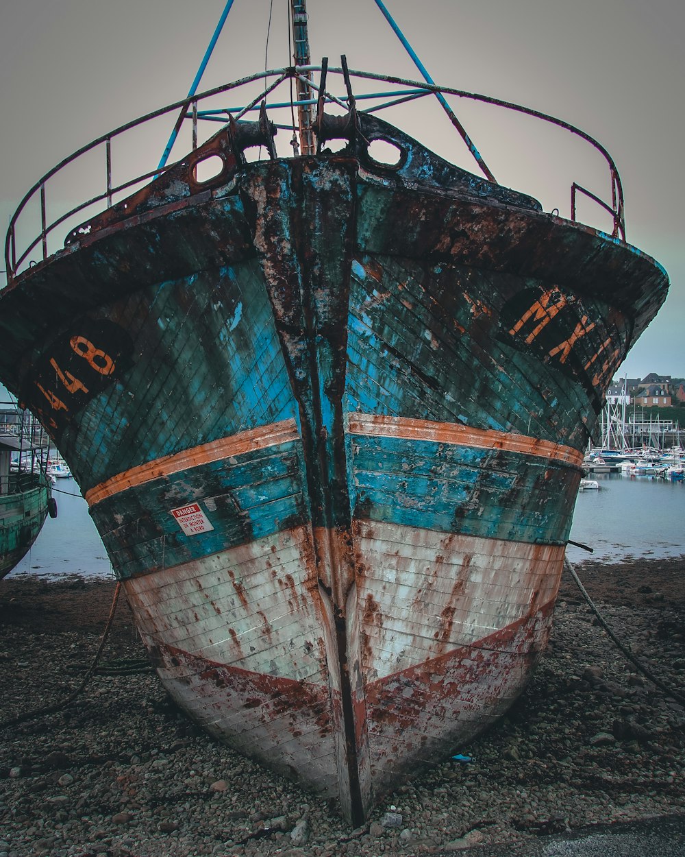 blue and white fishing boat on sea shore during daytime