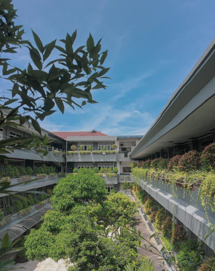 A bright, modern SMDC condominium building surrounded by lush greenery under a clear blue sky.