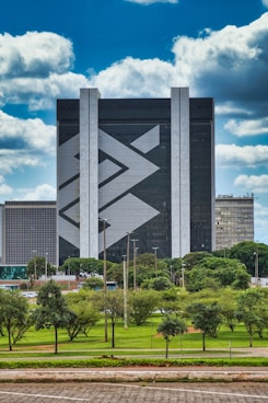 gray concrete building near green trees under blue sky during daytime