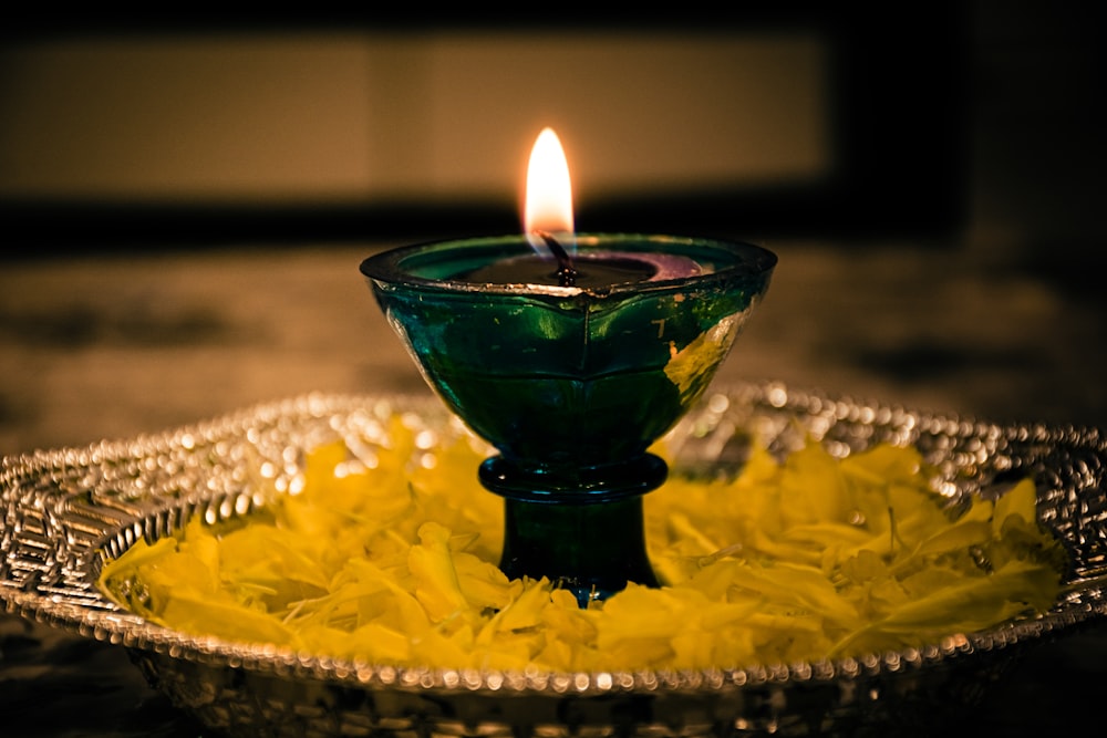 lighted candle in green glass holder