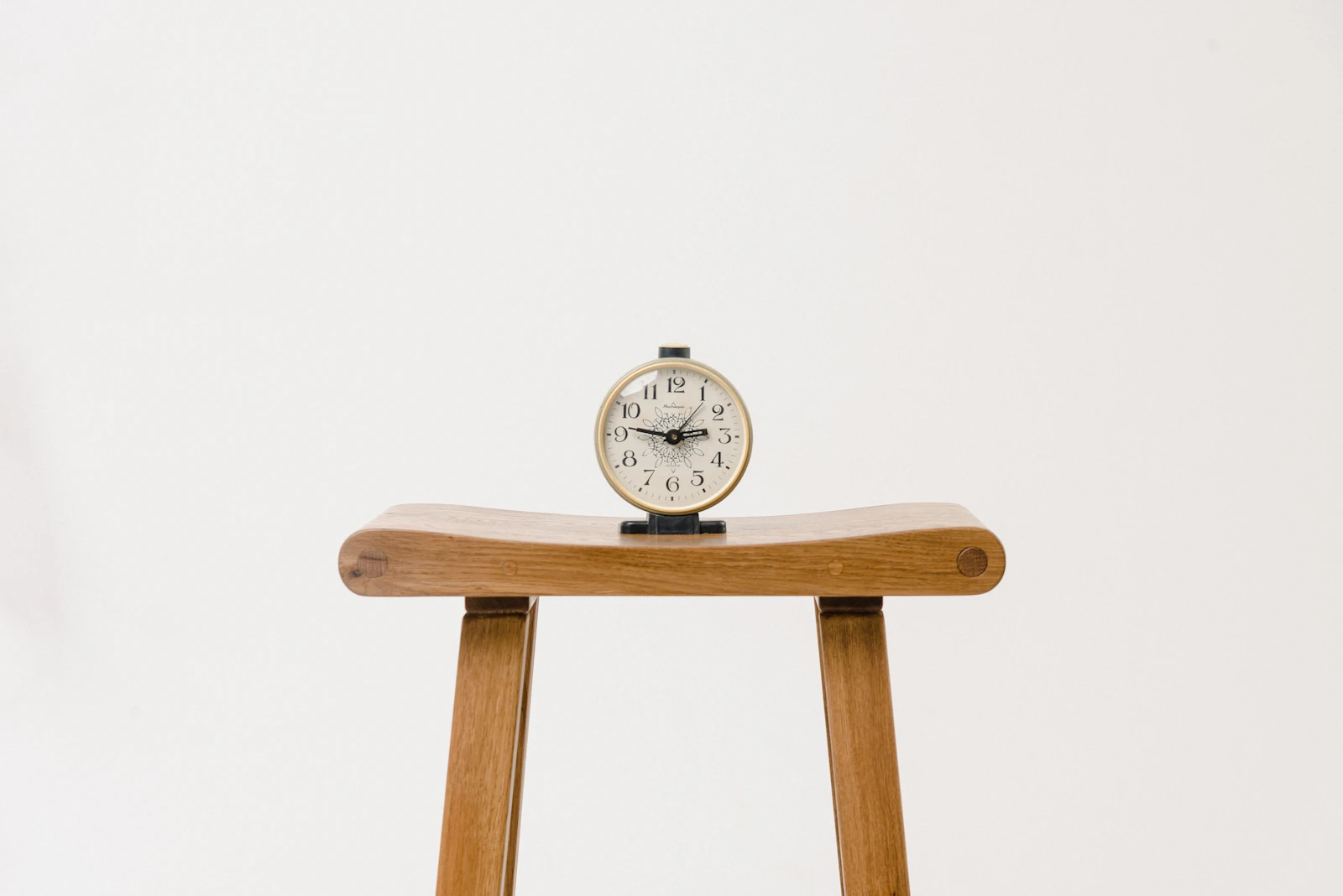 A wooden table clock showing the time