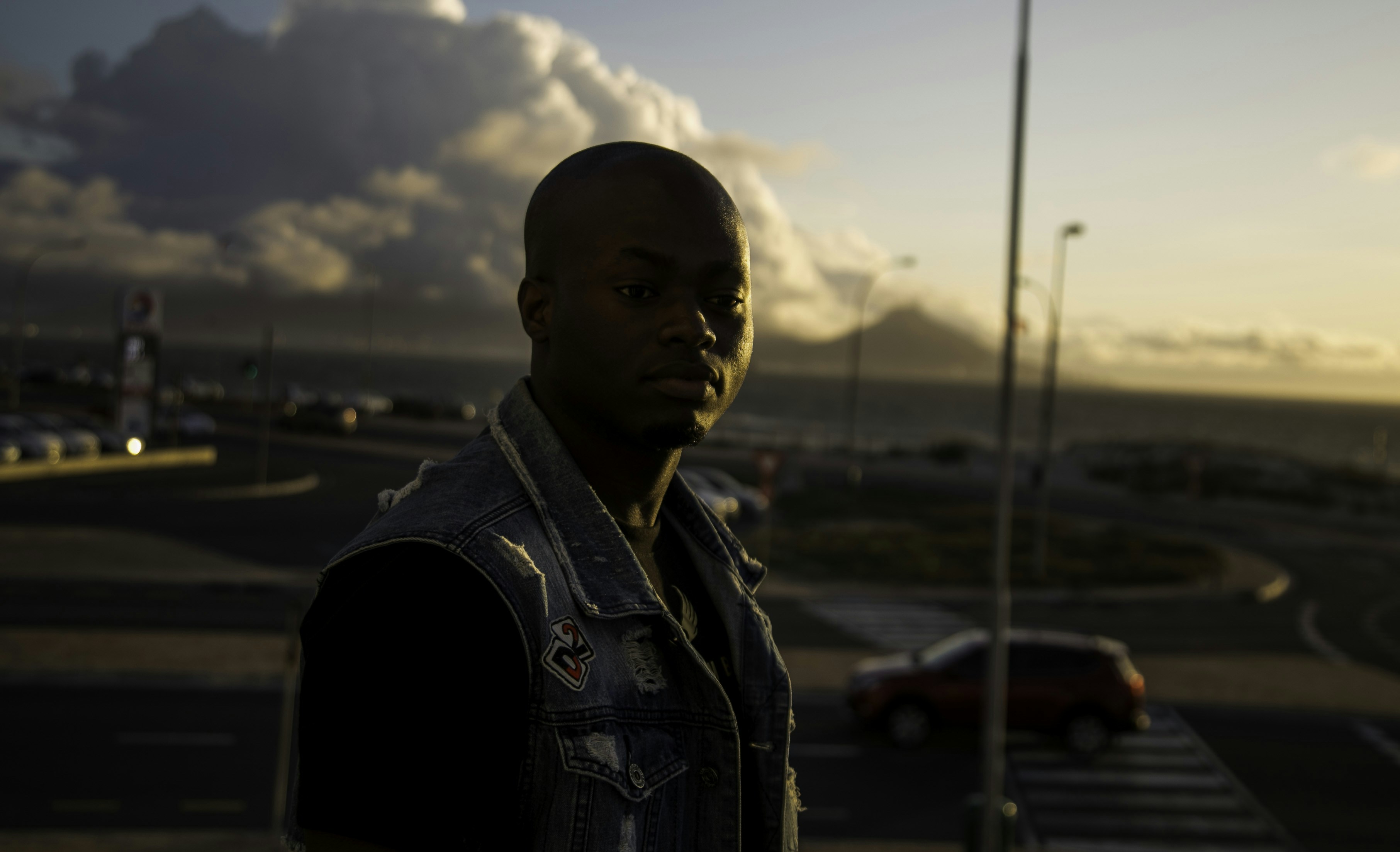 man in black jacket standing near road during daytime