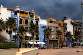 white and brown concrete building near palm trees during daytime
