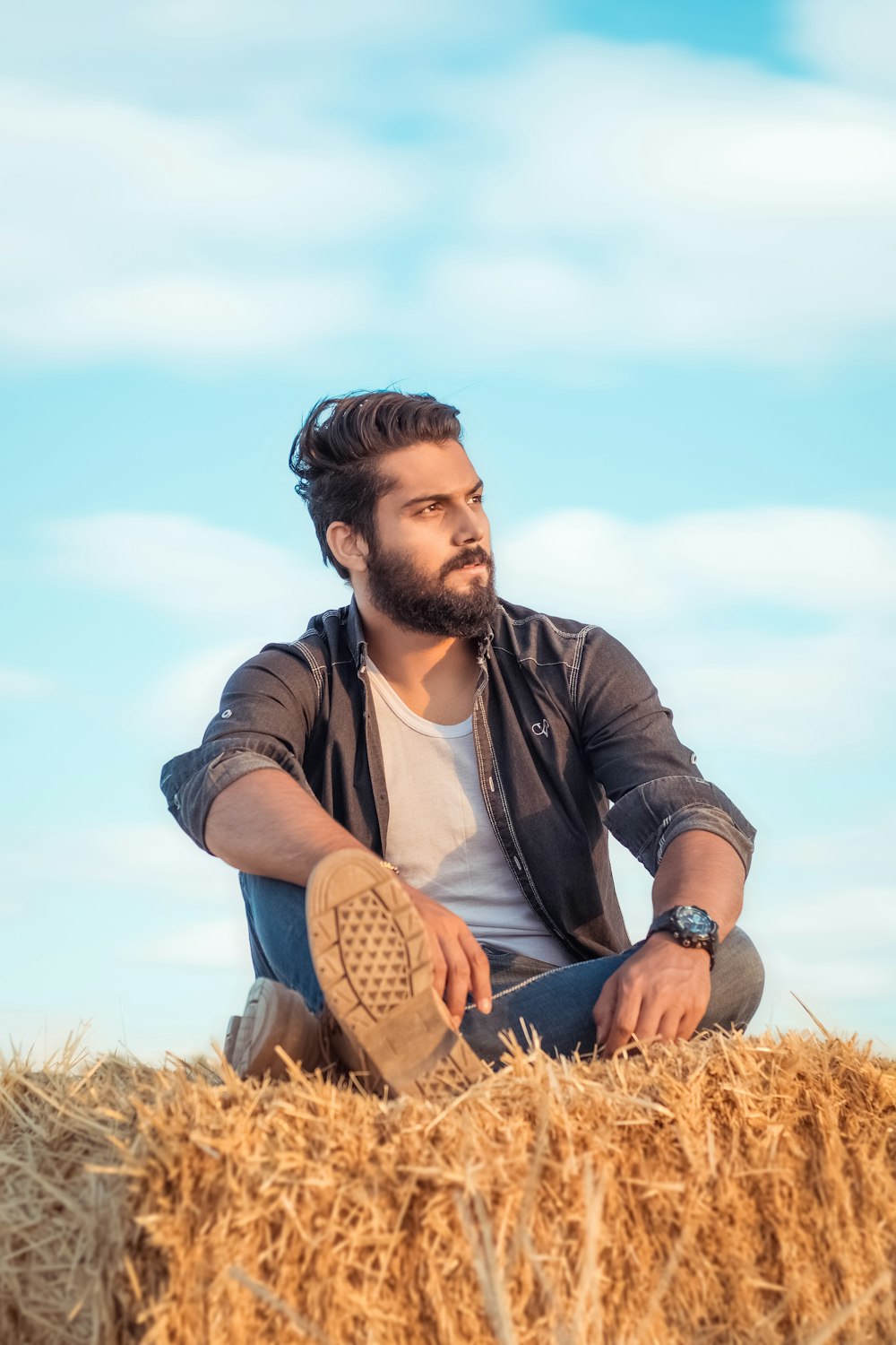 man in black leather jacket sitting on brown grass field during daytime