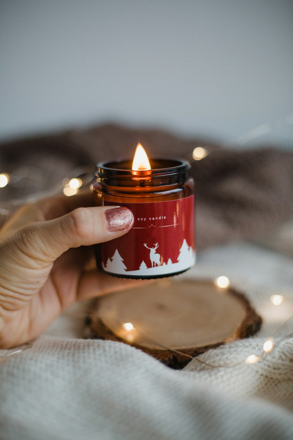 person holding red and white candle