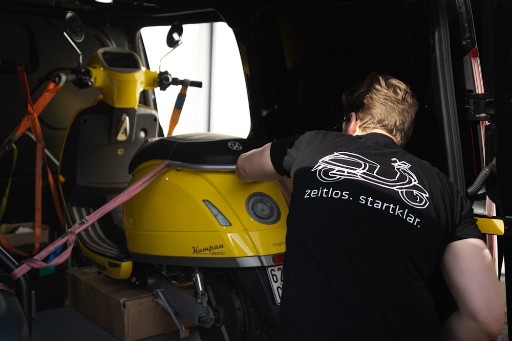 man in black shirt riding yellow and black motorcycle