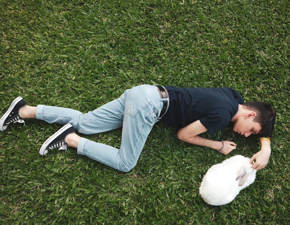 woman in black shirt lying on green grass field