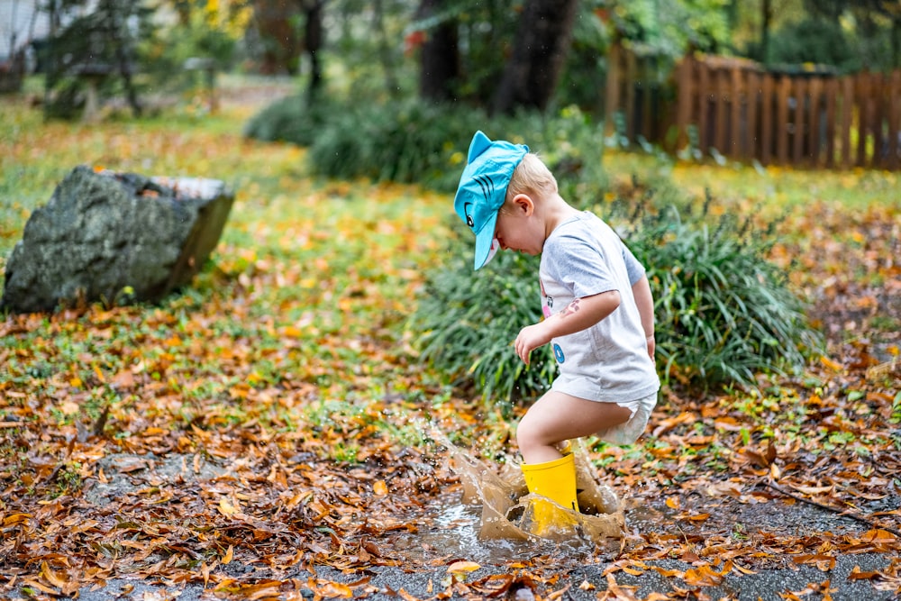 woman in white t-shirt and yellow pants with blue and yellow gloves on ground with near on on with