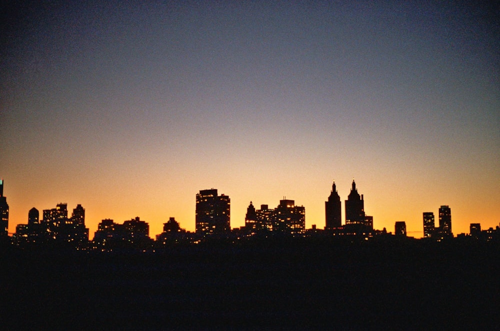 silhouette of city buildings during sunset