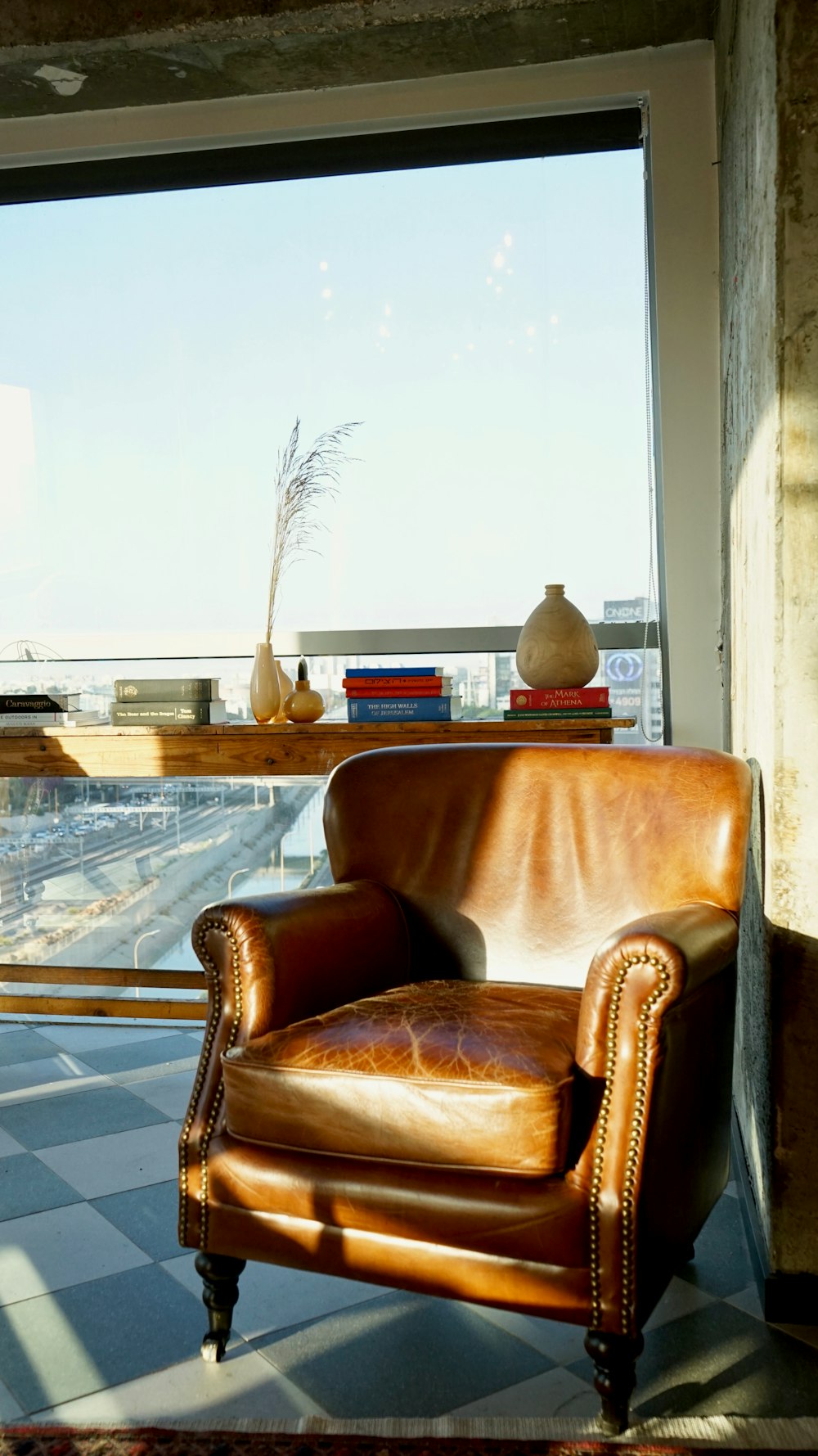 fauteuil en cuir marron à côté d’une table en verre
