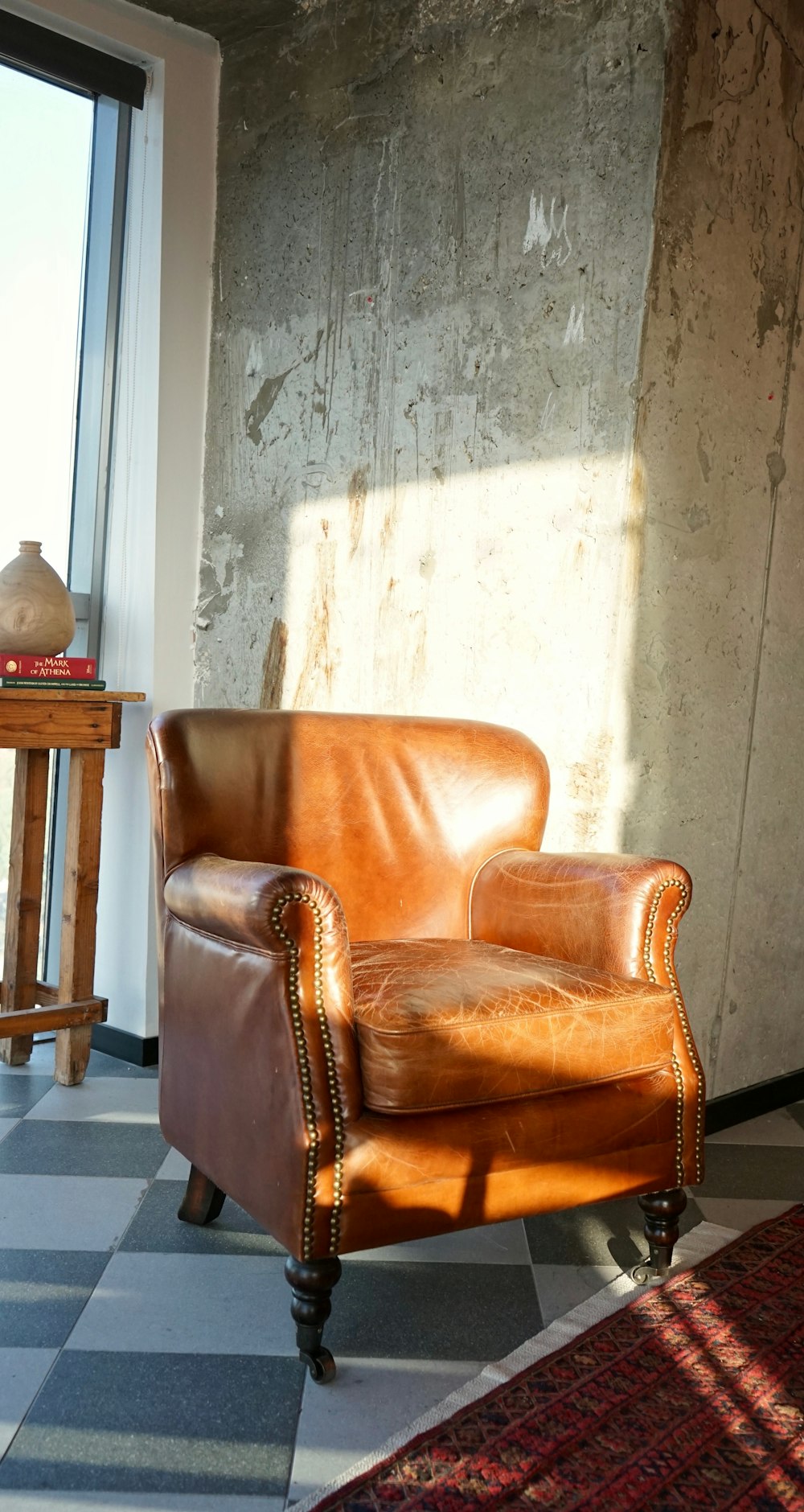 sillón de cuero marrón junto a mesa de madera marrón