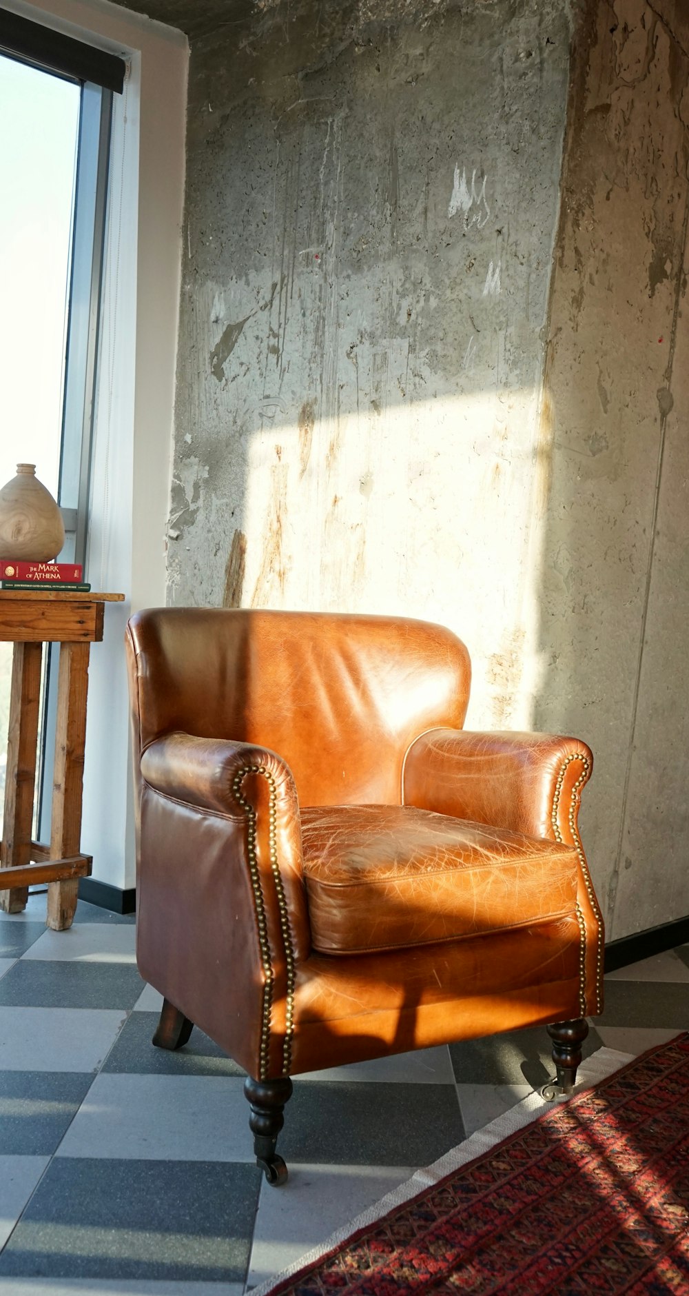 fauteuil en cuir marron à côté d’une table en bois marron
