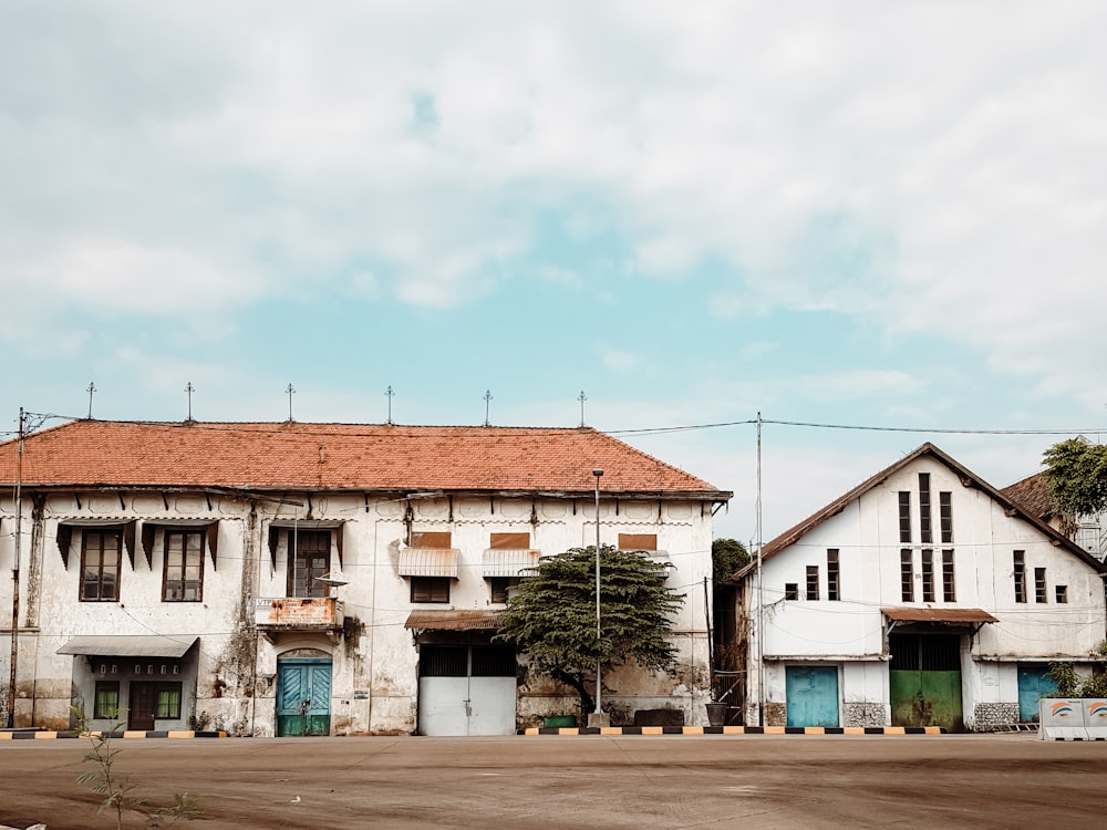 white and brown concrete houses under white clouds during daytime