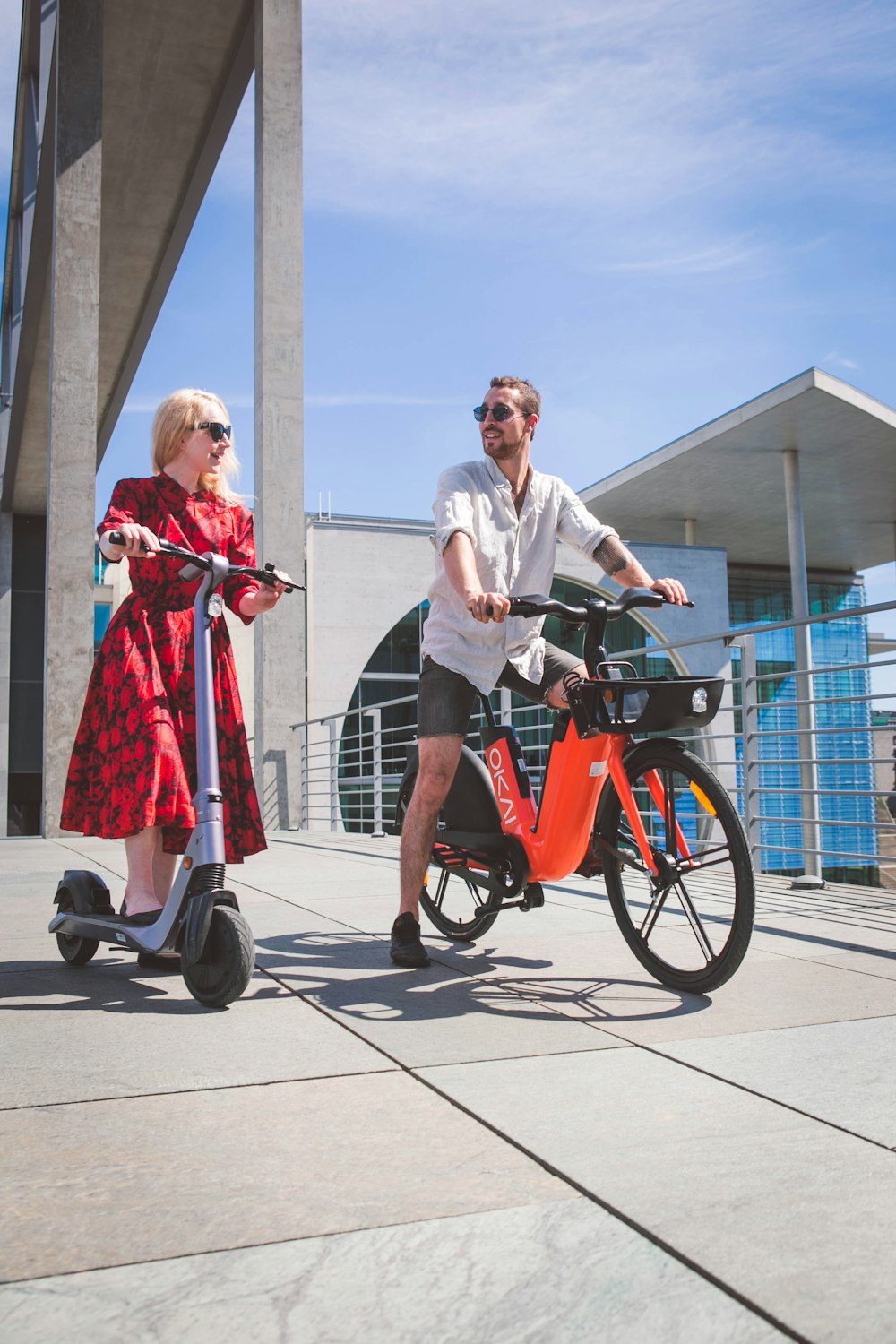 man in white dress shirt and woman in red dress riding on red and black trike