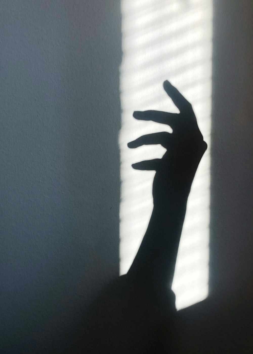 persons left hand near white window curtain