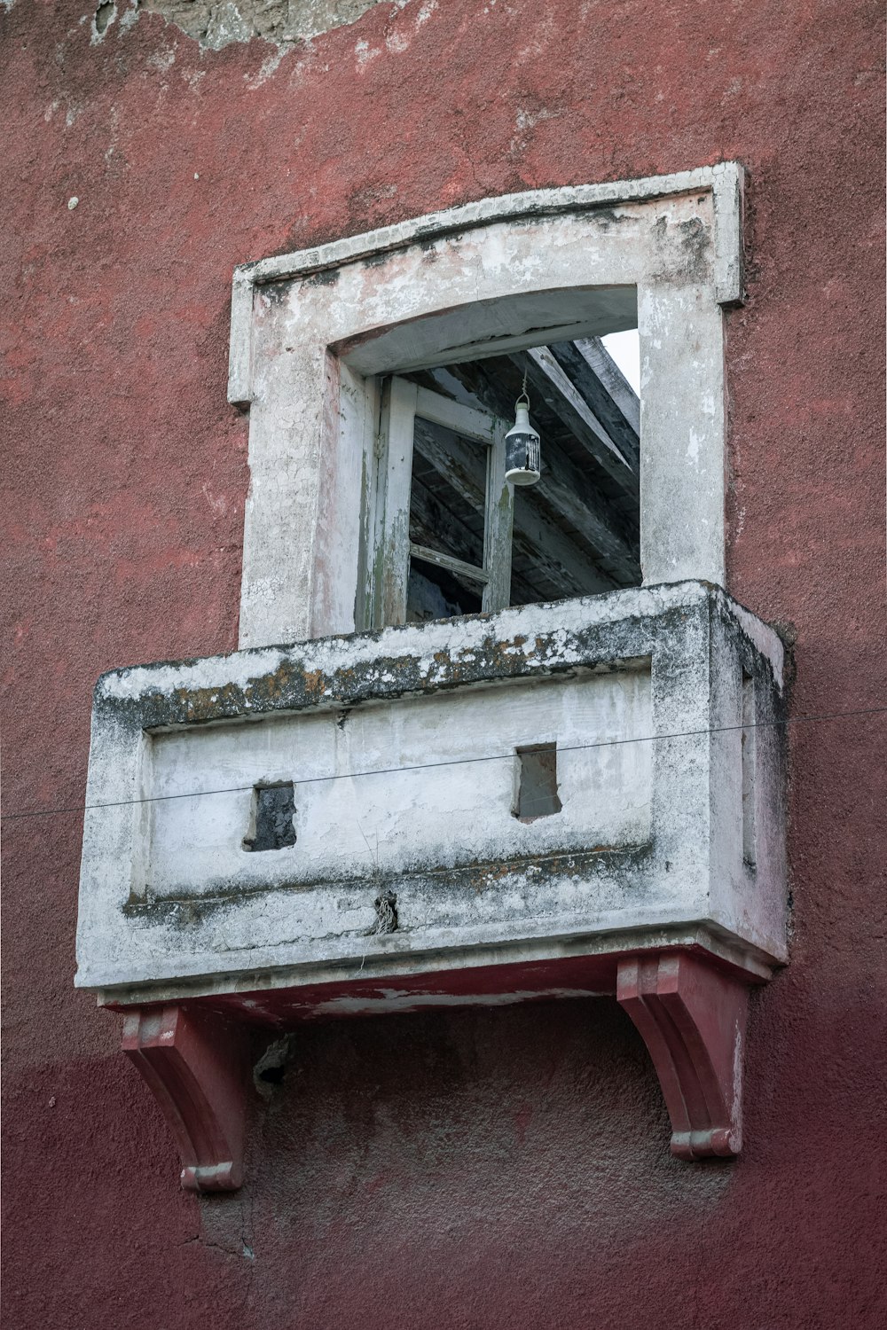 weißes Holzfenster an roter Betonwand