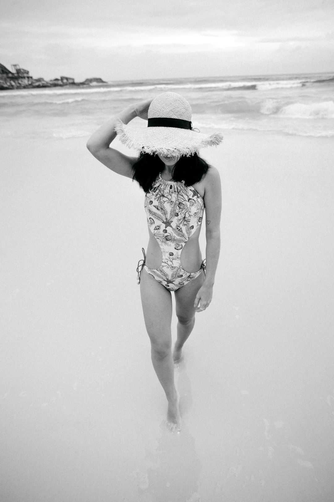 woman in black and white floral bikini standing on beach