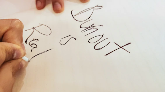 Close-up of hands writing notes during a stress management workshop.