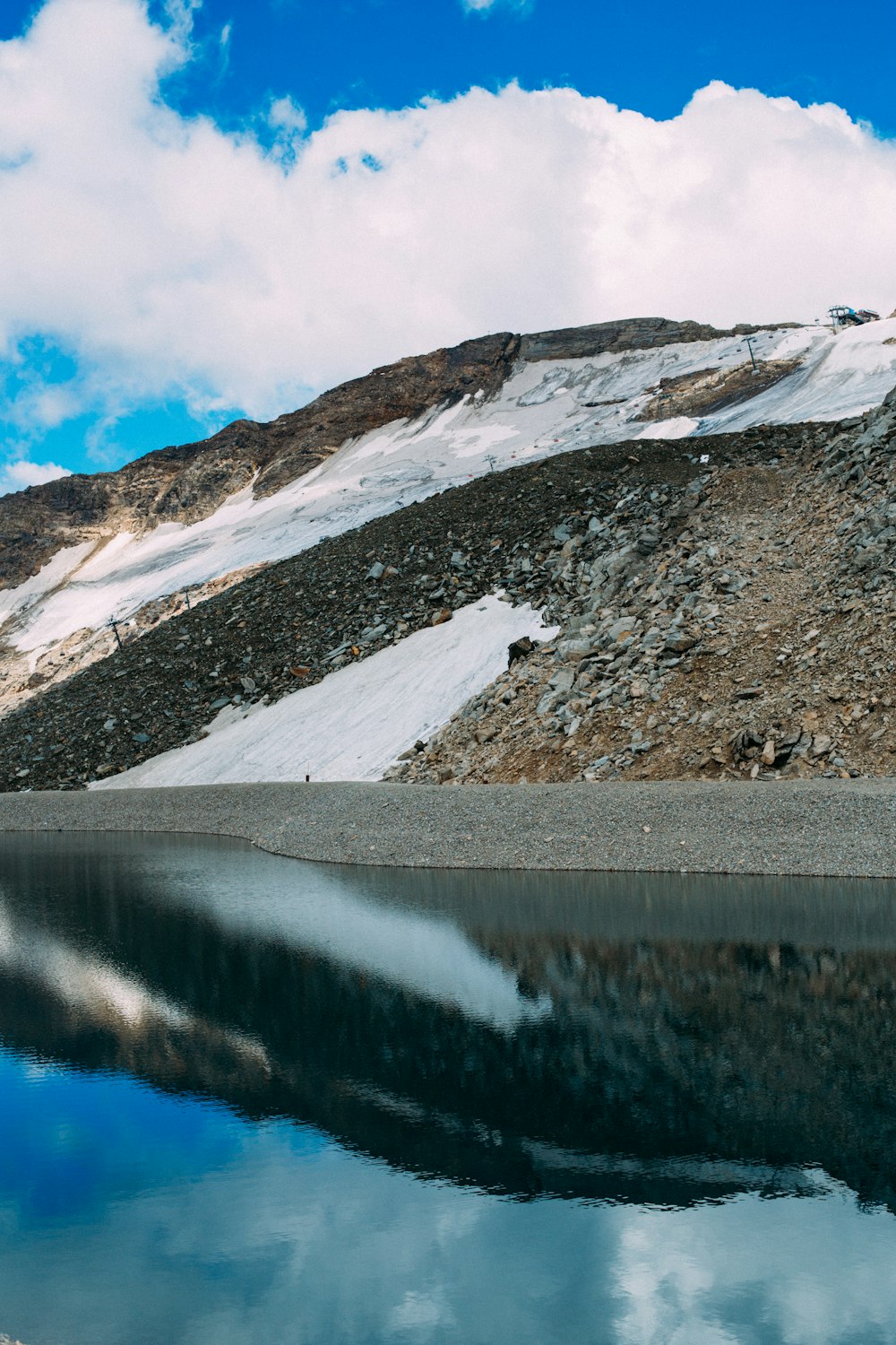 snow covered mountain near lake under blue sky during daytime