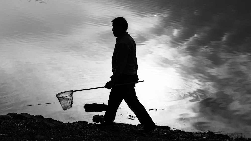 man in black jacket holding a stick