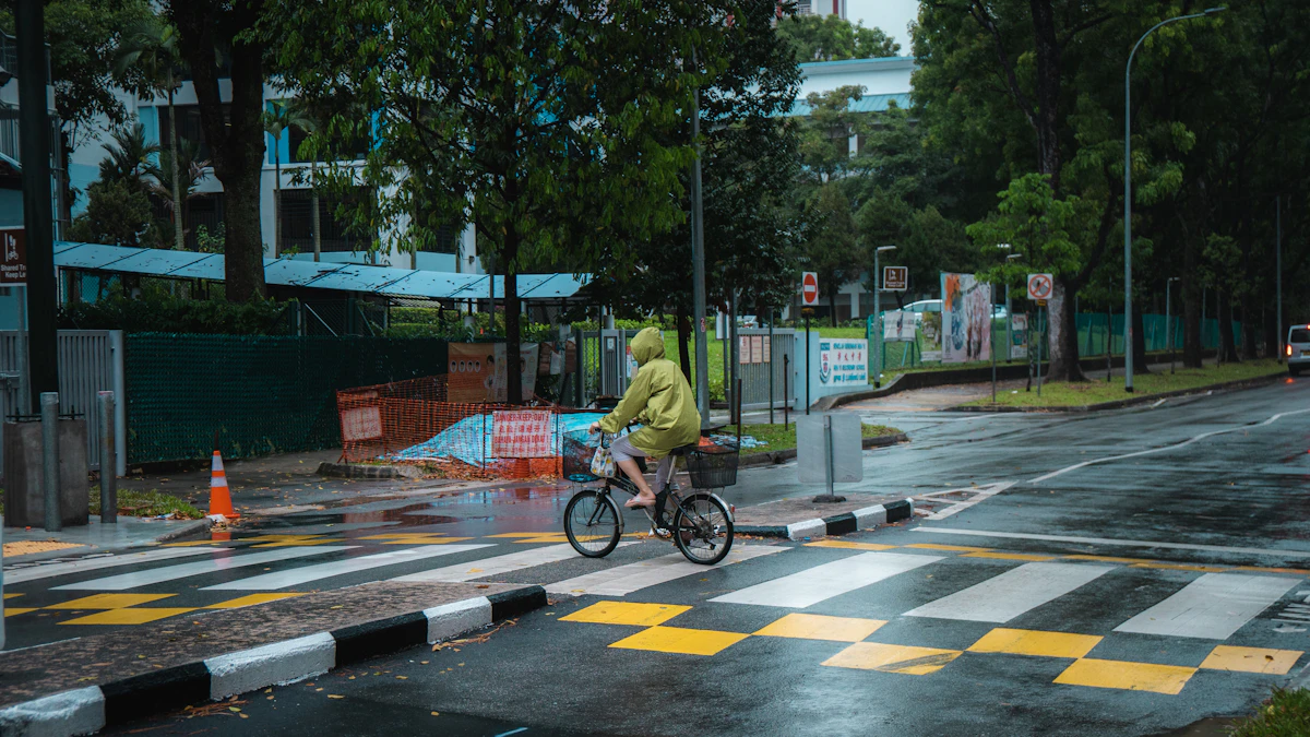 Fietser in felgele regenjas op een natte weg, van veraf goed zichtbaar in het verkeer