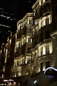Nighttime urban scene highlighting illuminated architectural details.