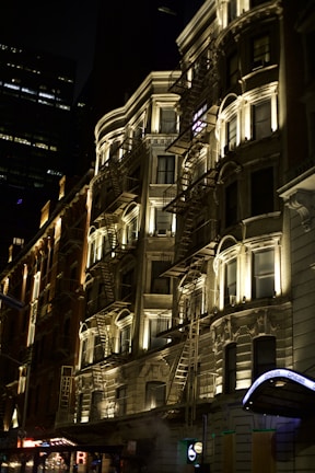 Nighttime urban scene highlighting illuminated architectural details.