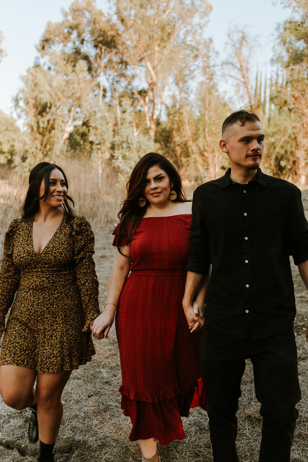 man in black dress shirt standing beside woman in red dress