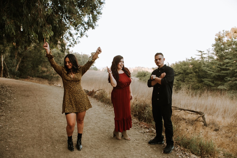 3 women standing near green trees during daytime