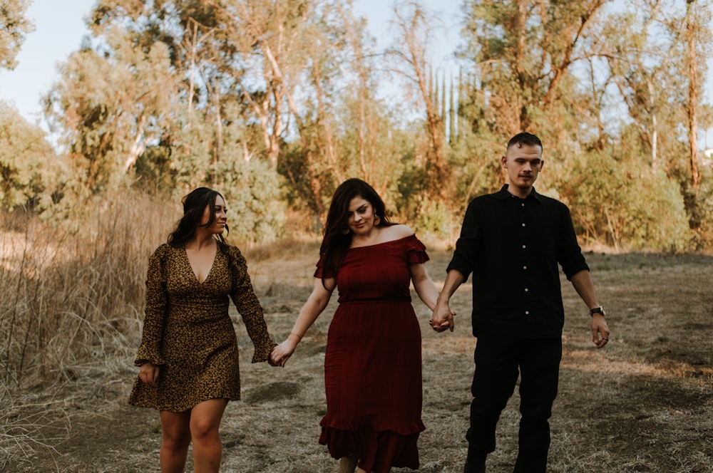 man in black long sleeve shirt standing beside woman in red dress