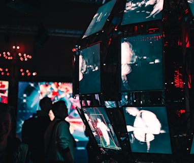 a group of people standing around a display of video screens