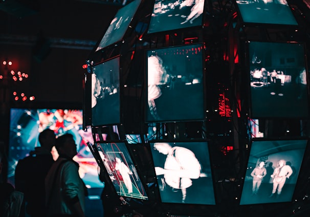 a group of people standing around a display of video screens