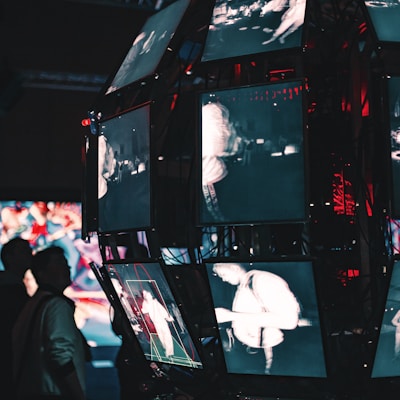 a group of people standing around a display of video screens