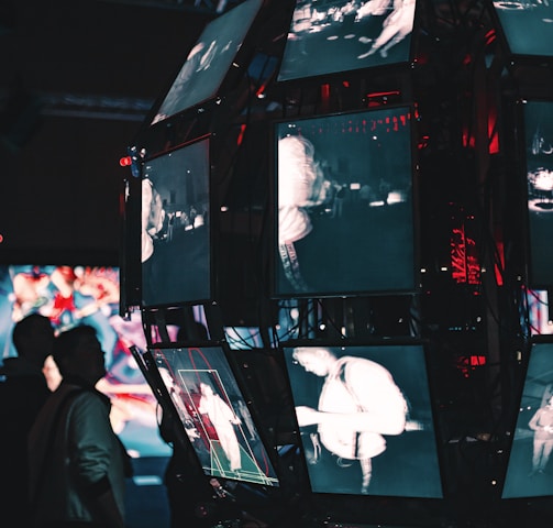 a group of people standing around a display of video screens