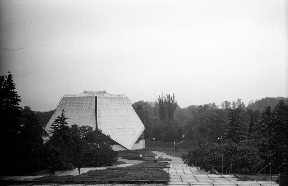 grayscale photo of building near trees