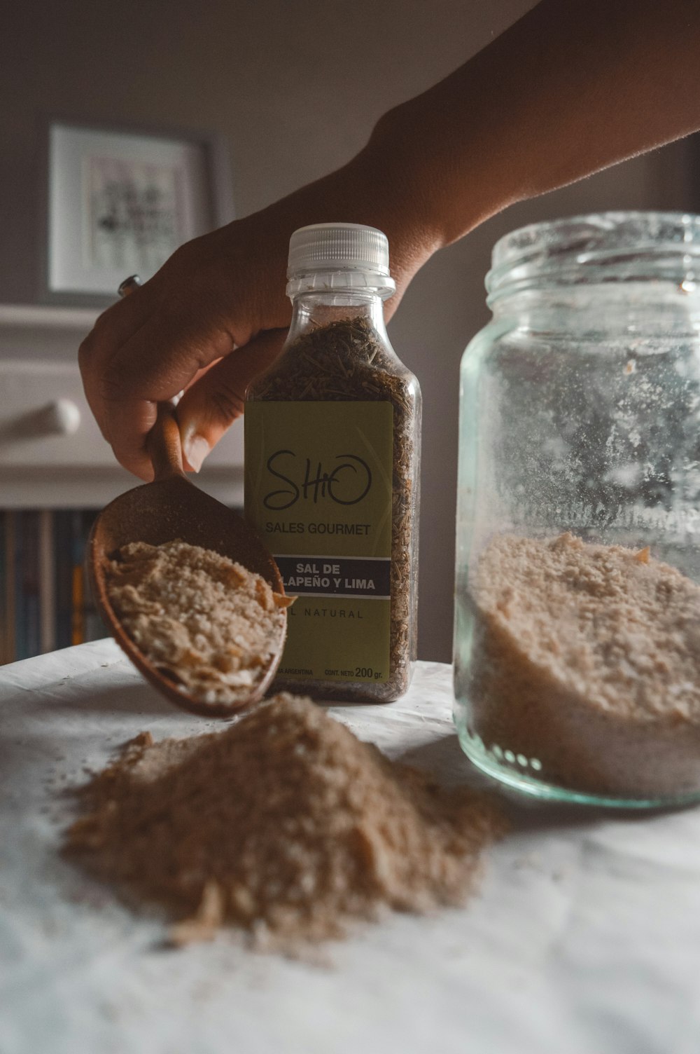 a person holding a spoon over a jar of oatmeal