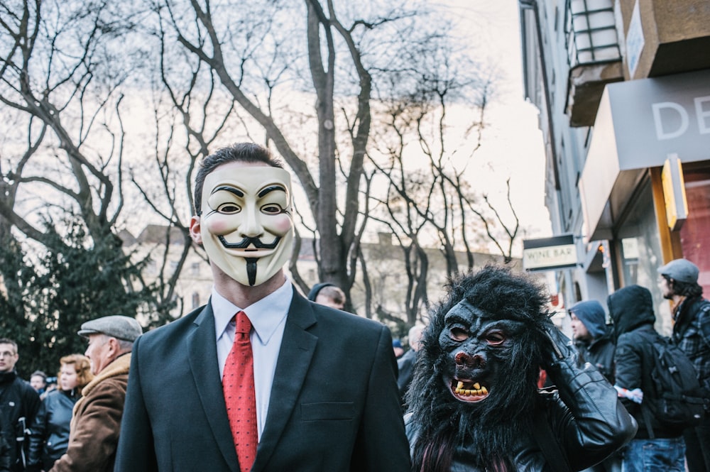 man in black suit jacket wearing black and white mask